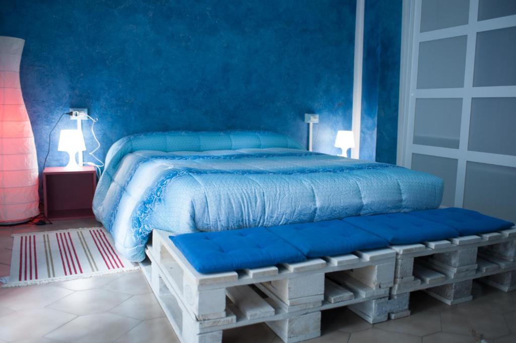 CastelfrentanoB&B Casa Tua的一间蓝色卧室,配有床和长凳