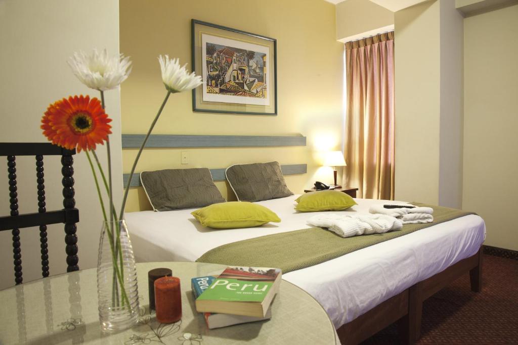 利马卡马纳酒店 的配有一张床和花瓶的酒店客房