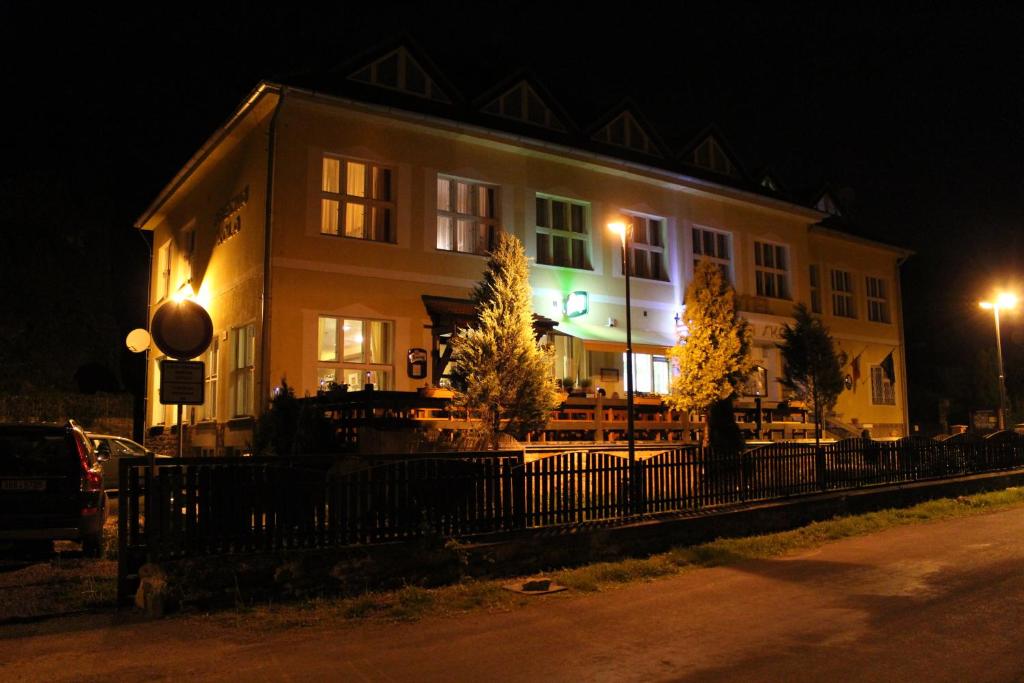 Svatý Jan pod SkalouHotel Obecná Škola的一座建筑,在晚上前有栅栏