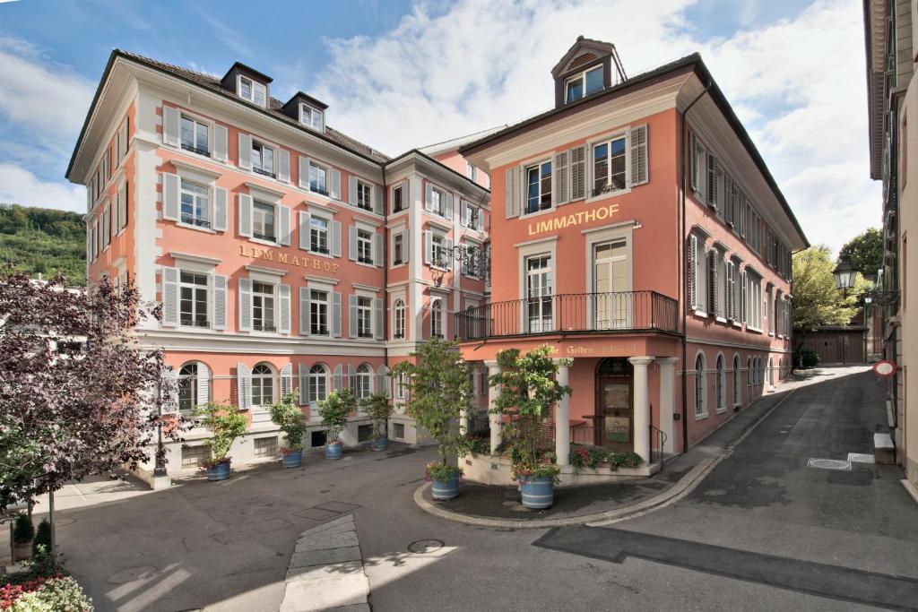 巴登Limmathof Baden - Historisches Haus & Spa的前面有一条街道的粉红色大建筑