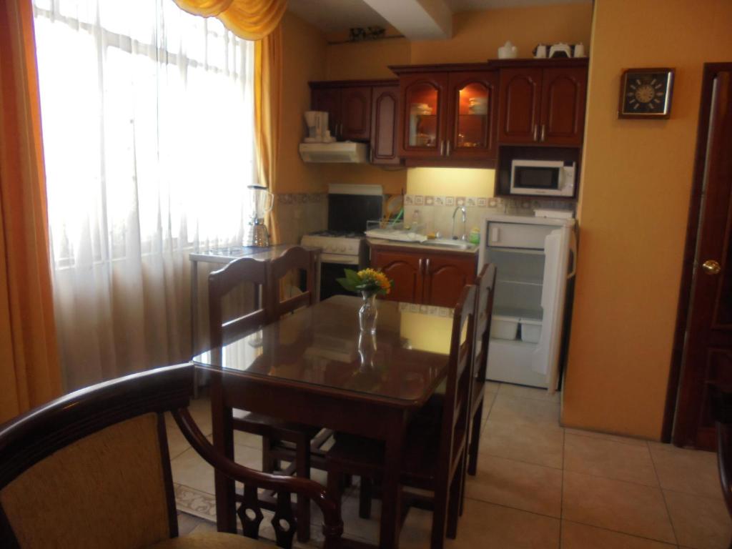 里奥班巴Chimborazo的一间带桌椅的厨房和一间带冰箱的厨房