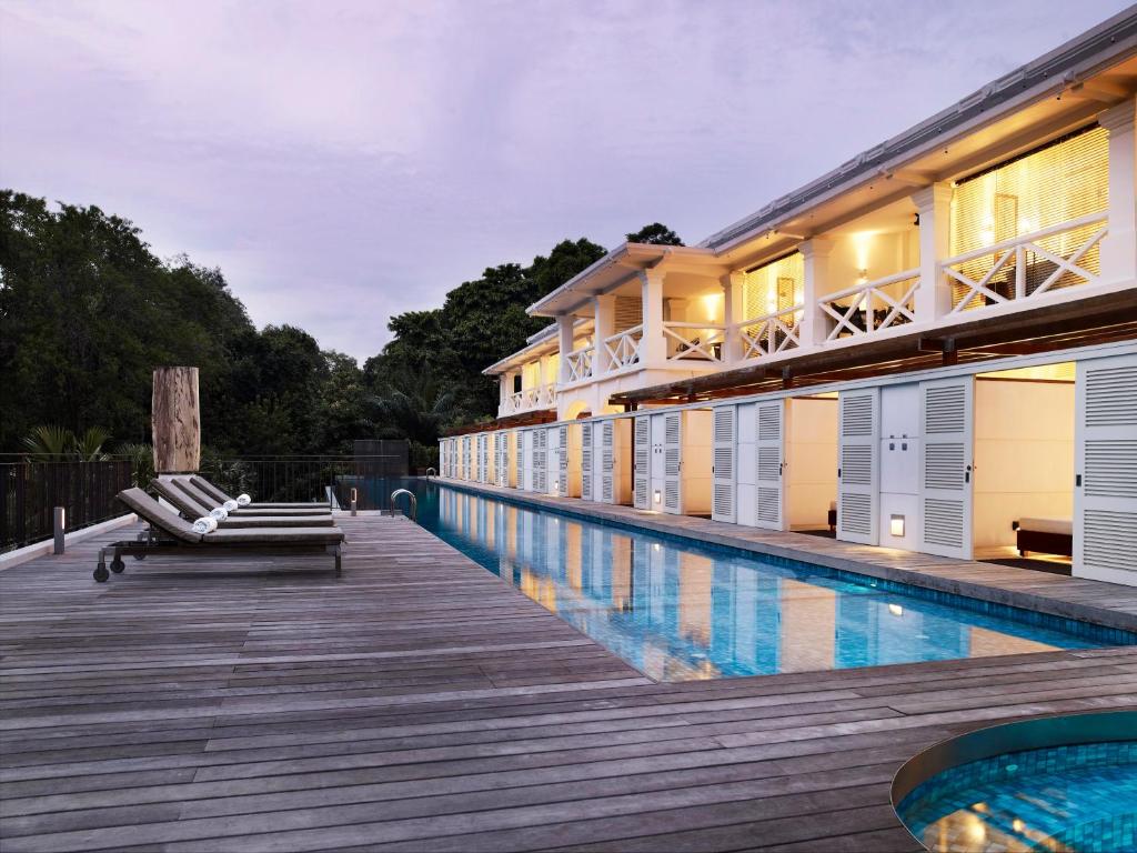新加坡Amara Sanctuary Resort Sentosa的一座带游泳池和大楼的度假村