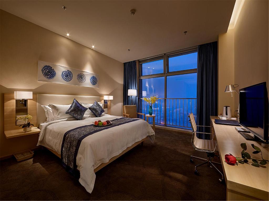 石家庄石家庄诺华廷酒店 Novlion hotel的一间卧室配有一张床、一张书桌和一台电视