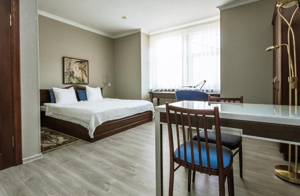 里加Hotel Kert FREE PARKING的配有一张床、一张桌子和一张桌子的酒店客房