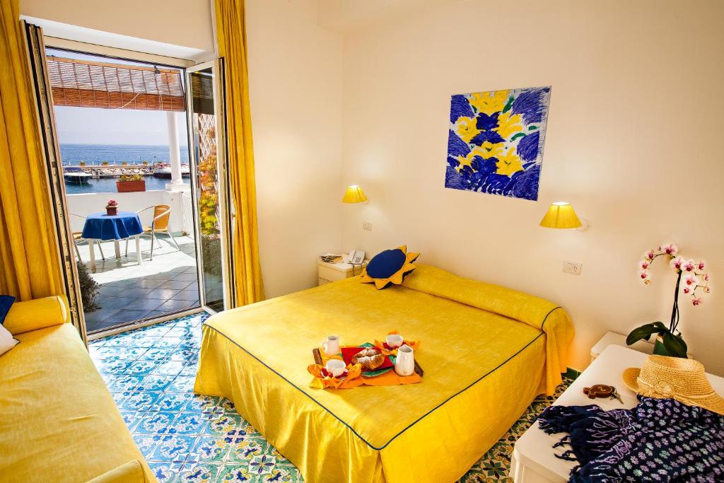 伊斯基亚Hotel La Sirenella的一间卧室设有一张黄色的床和一个阳台