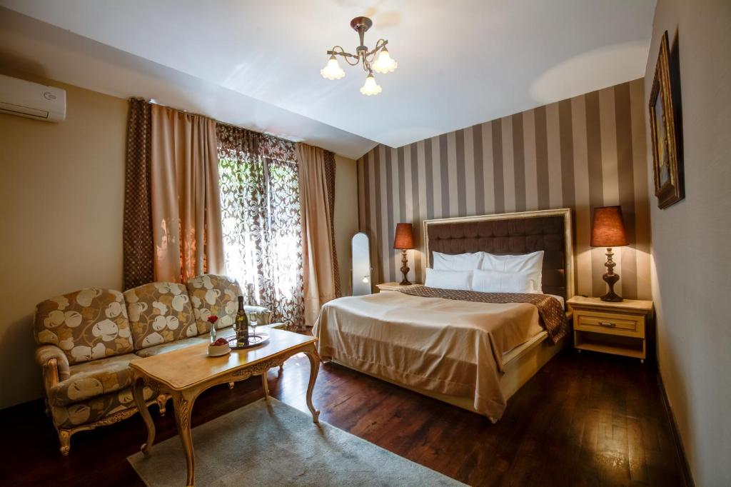 贝尔格莱德斯加达尔里加别墅酒店的酒店客房,配有床和沙发