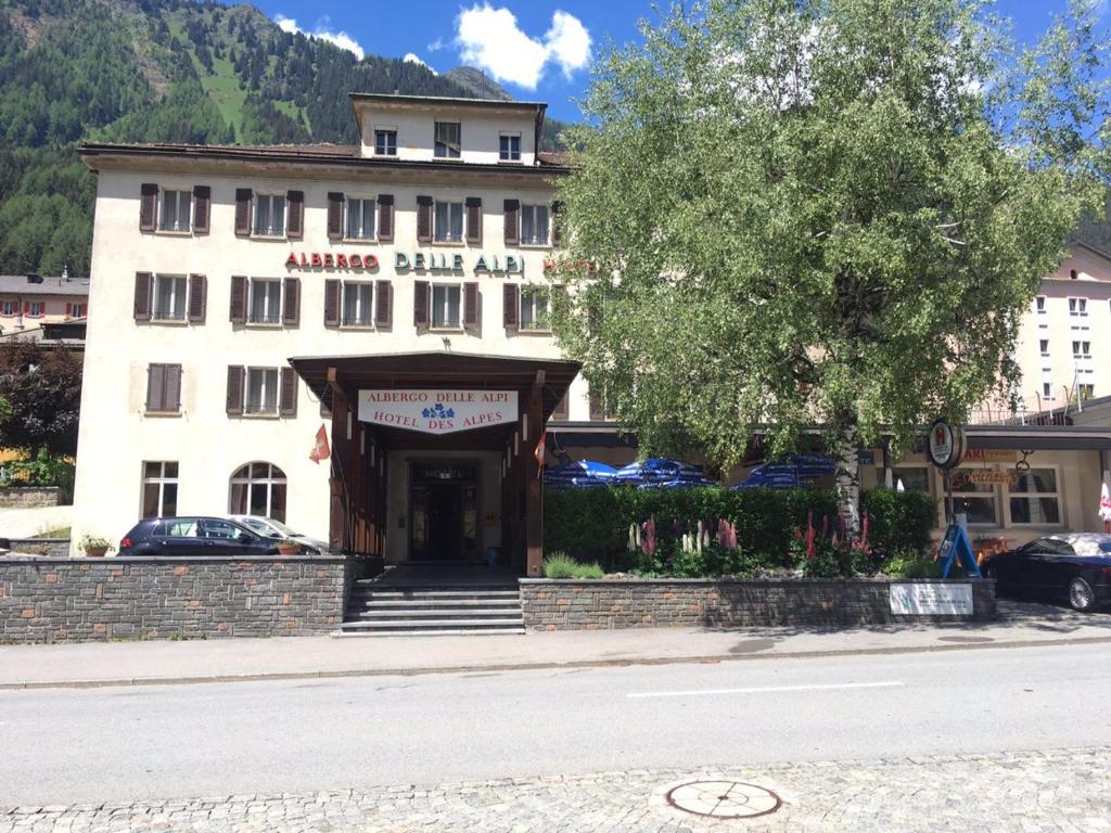 艾罗洛Hotel Des Alpes - Restaurant & Pizzeria的前面有标志的大型白色建筑