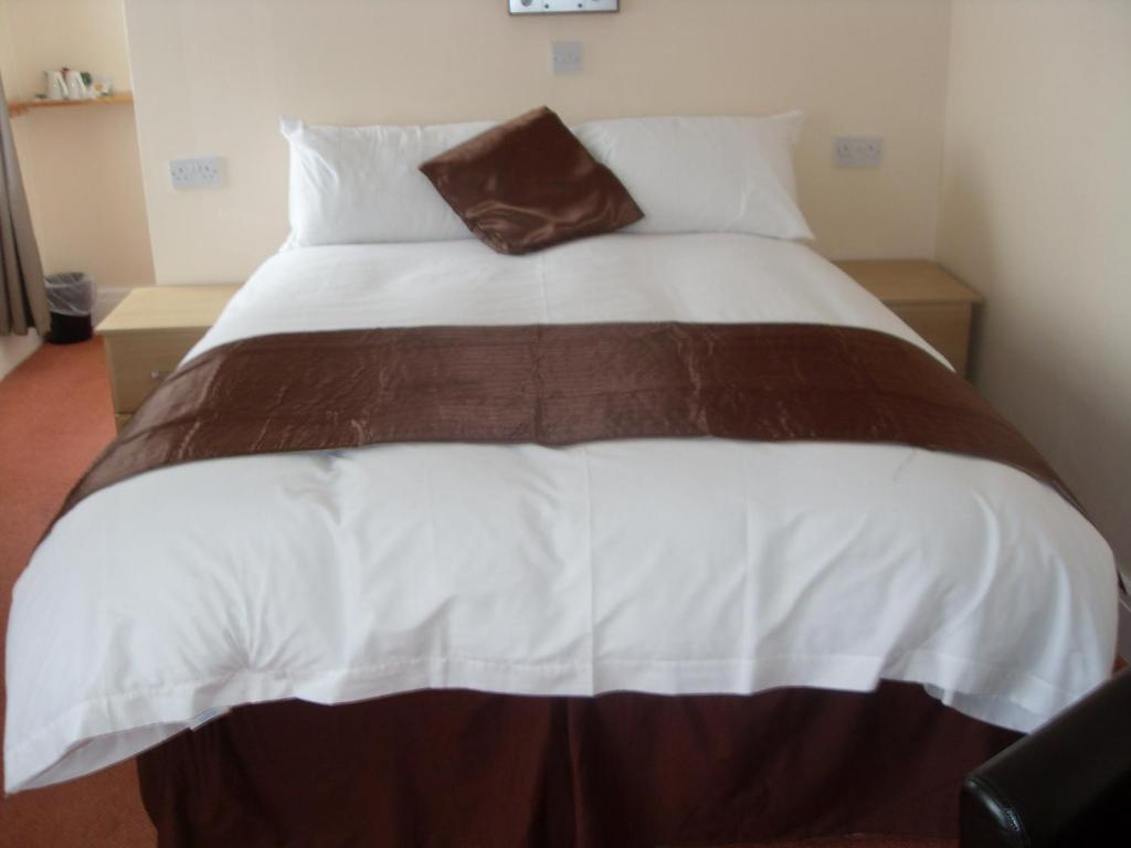 桑德斯富特梅伍德酒店的一张带棕色和白色棉被的大床