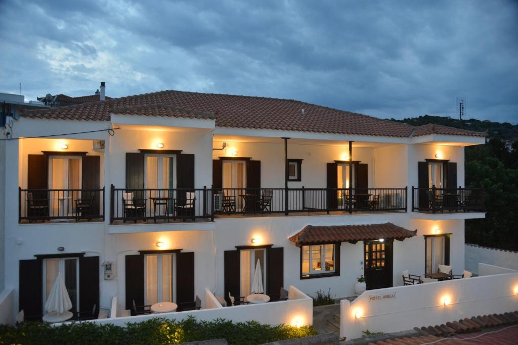 斯科派洛斯安娜丽酒店的一间大型白色房子,晚上设有阳台