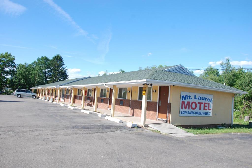黑兹尔顿Mount Laurel Motel的停车场内带有汽车旅馆标志的建筑