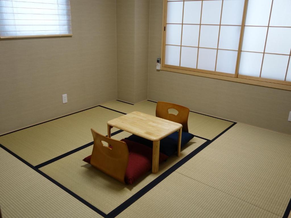 京都京都温德维拉旅馆的一间位于地板上并配有桌椅的房间