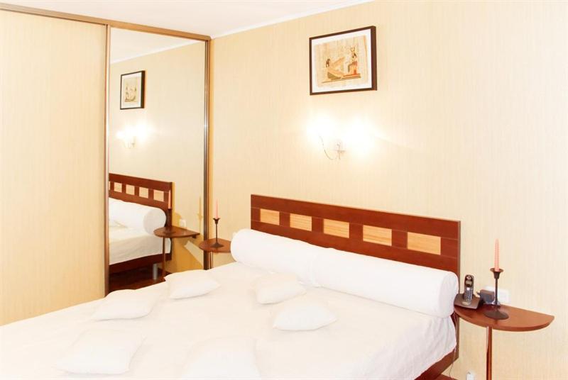 沃罗涅什MEGAPOLIS улица Никитинская 21-70的卧室配有一张白色大床和镜子