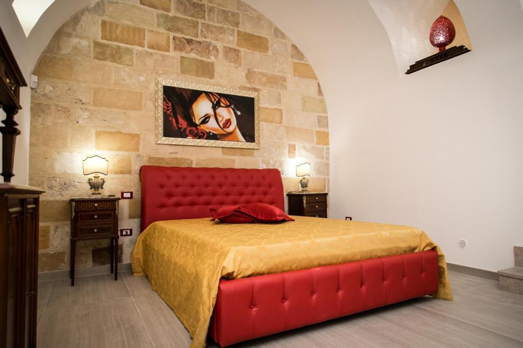 科佩尔蒂诺Casa a Corte的一间卧室设有红色的床和石墙