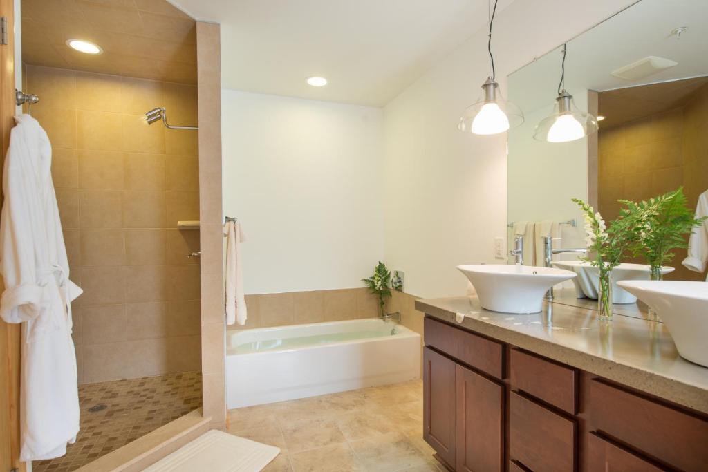 DarienRiver Spring Lodge的浴室配有2个盥洗盆、浴缸和淋浴。