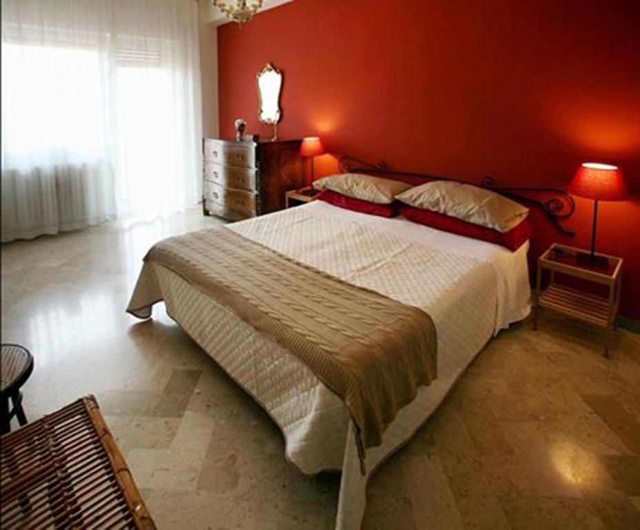 马泰拉微笑公寓的一间卧室设有一张红色墙壁的大床