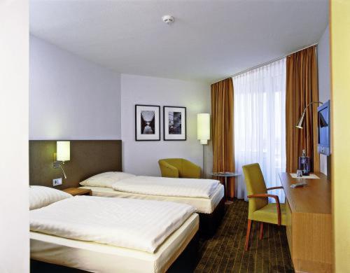 克尔彭ABZ欧文奈特塔格昂斯酒店的酒店客房设有三张床和一张书桌