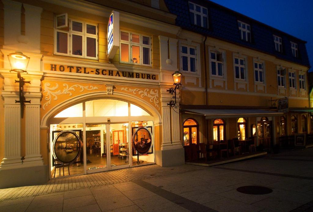 霍尔斯特布罗绍姆堡酒店的夜间街道上一座酒店式建筑,有拱门