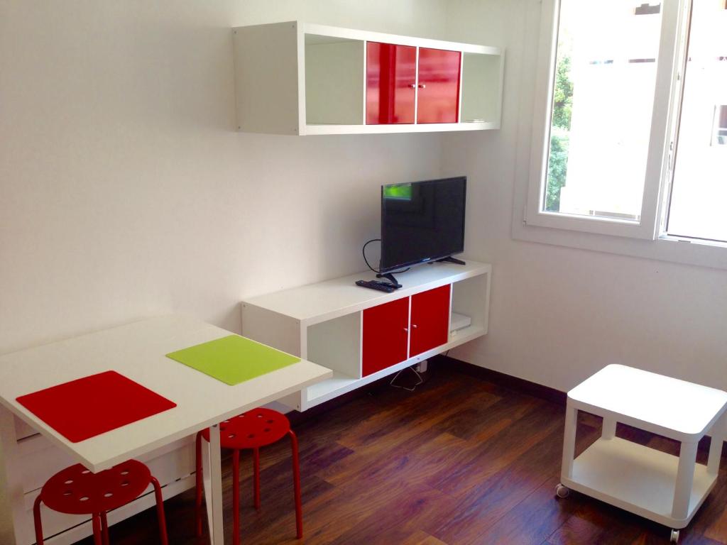 昂蒂布Studio La Reine Astrid的小房间设有桌子和带电视的书桌