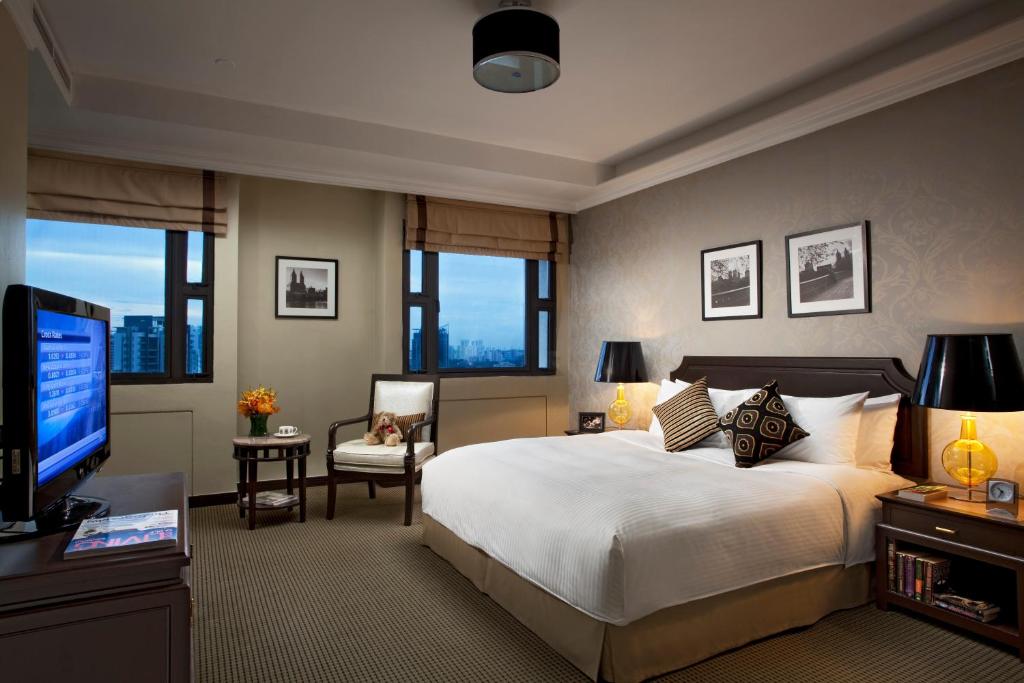 新加坡远东酒店集团乌节路公园套房酒店的一间卧室配有一张大床和电视