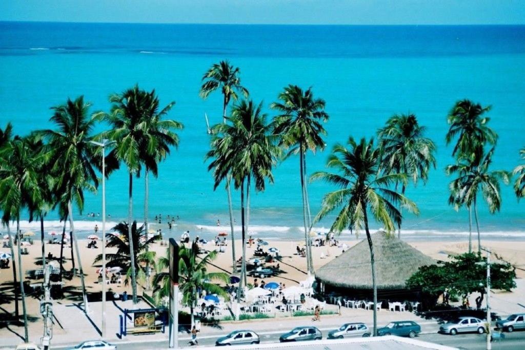马塞约Apartamento Praia Jatiúca的享有棕榈树和汽车海滩的景色