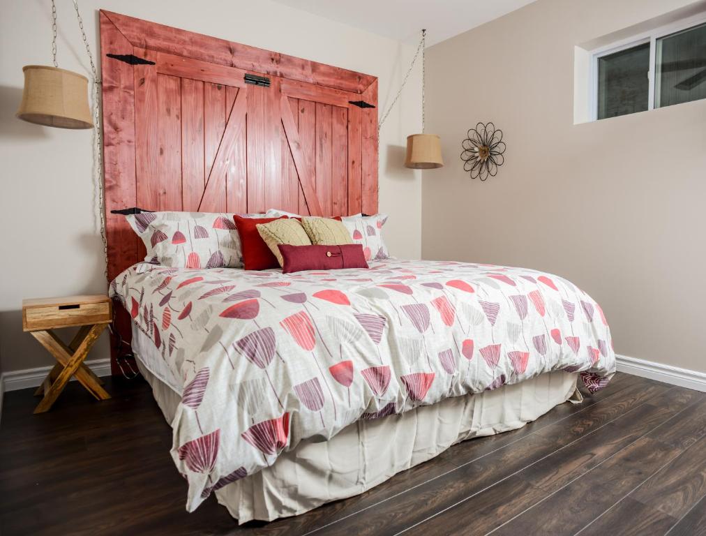 惠灵顿乡村套房公寓的一间卧室配有一张大床和木制床头板