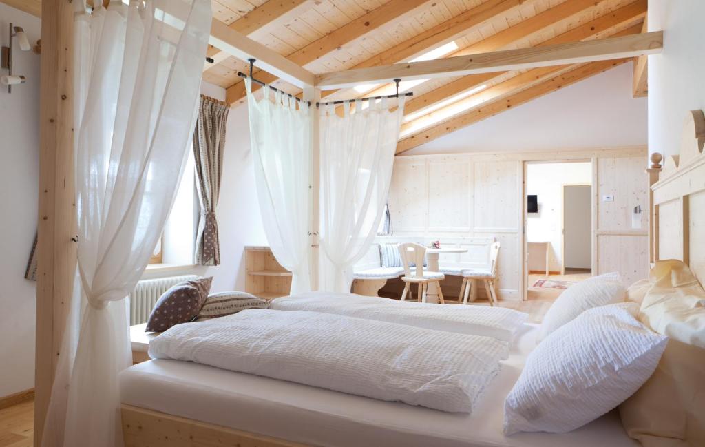 Roncegno克罗纳塔住宿加早餐旅馆的卧室设有2张床和木制天花板。
