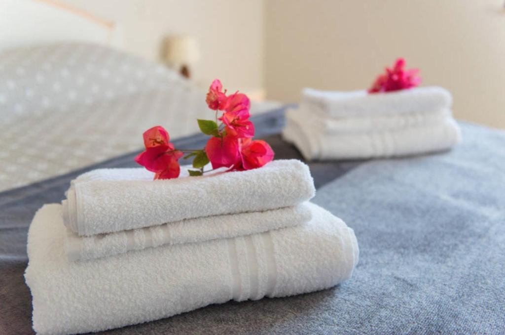 夸尔图-圣埃莱娜Poetto Beach的床上的3条毛巾,带鲜花