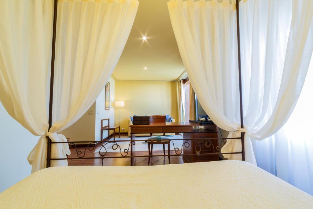 布尔戈斯阿索弗拉酒店的一间卧室配有白色窗帘的床