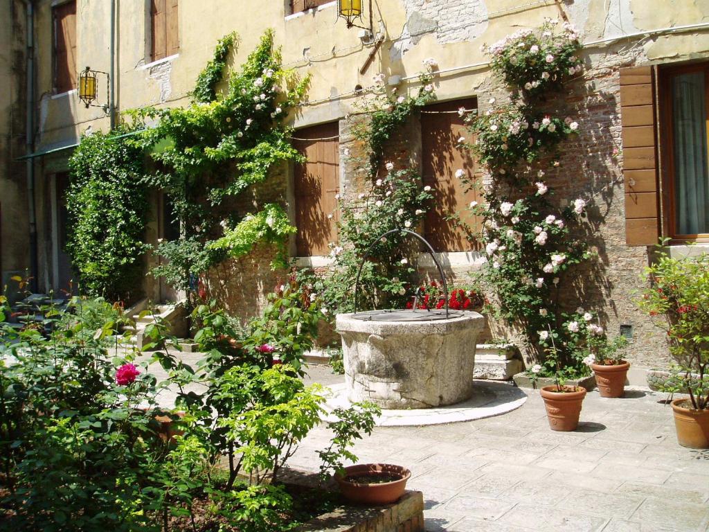 威尼斯多姆斯西利欧塔酒店的一座花园,在一座建筑前种有鲜花和植物