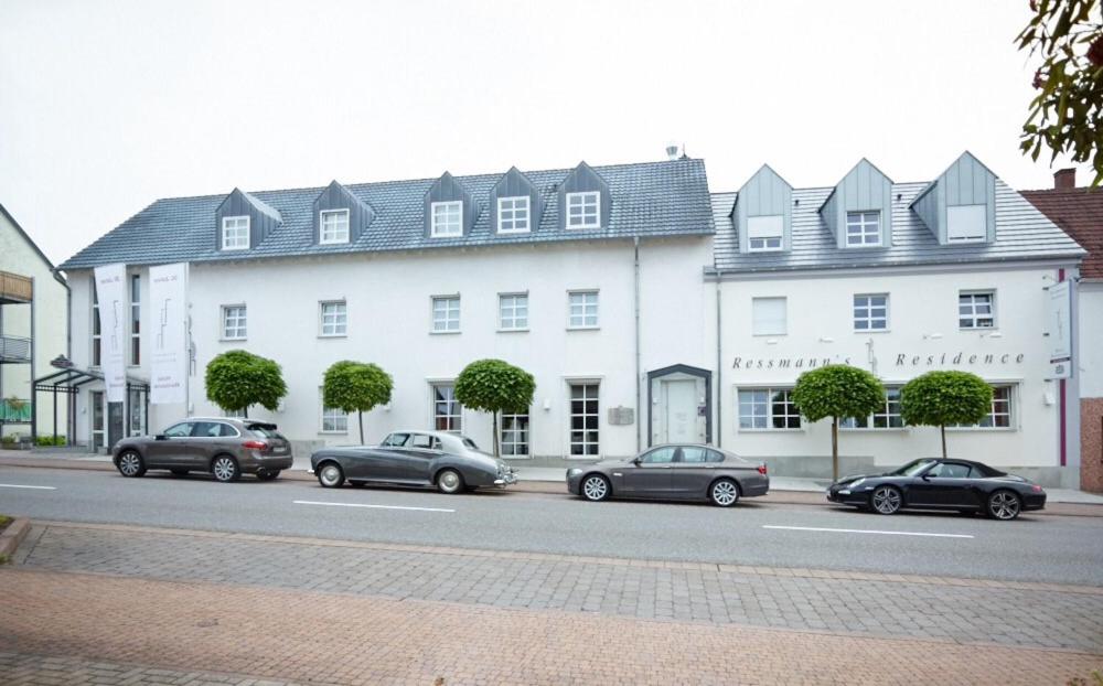 KirkelRessmann`s Residence的停在白色建筑前的一组汽车