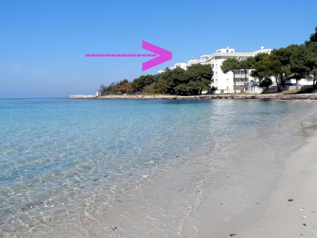 加利波利La Spiaggia sotto Casa的箭头指向地平线的海滩图像
