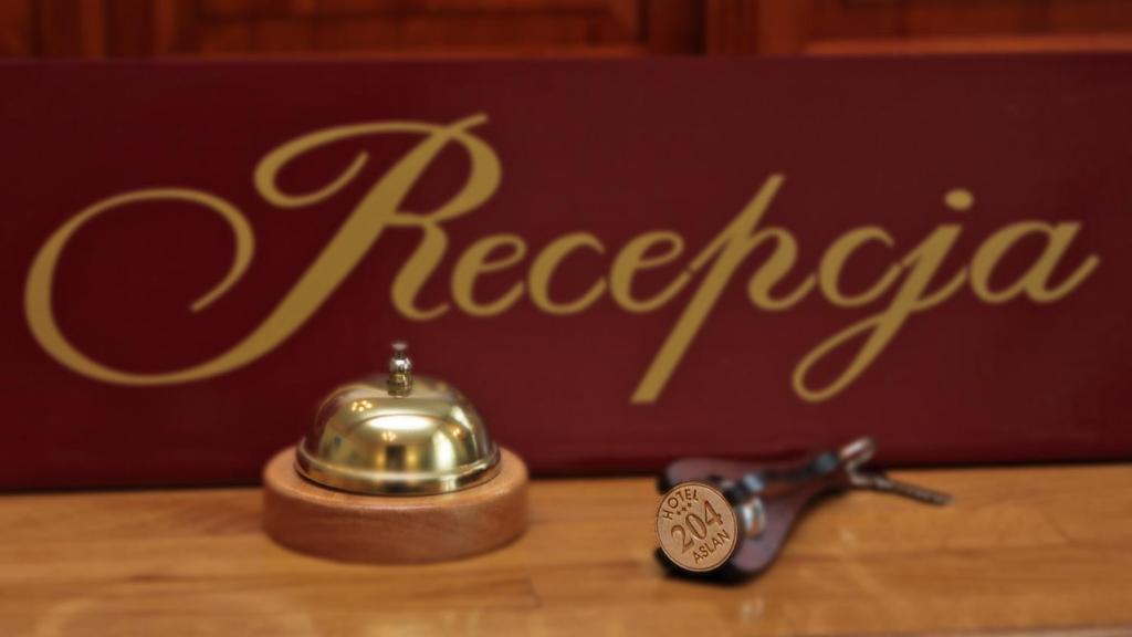 塔尔诺夫斯凯古雷Hotel Aslan的茶壶和桌子上的桌子上带有唱片标志的茶匙