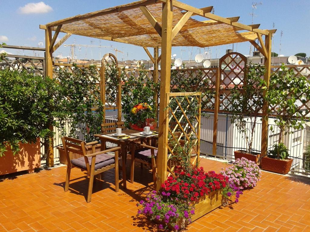 罗马Holiday rental St Peter's area的庭院配有桌椅和鲜花