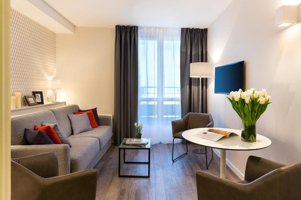 巴黎馨乐庭巴黎蒙马特尔酒店的客厅配有沙发和桌子