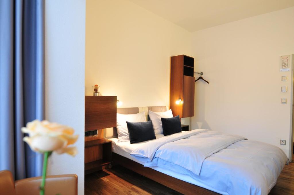 科隆科隆林特酒店的一间卧室配有一张带白色床单和花卉的床。