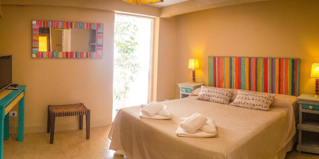 普尔马马尔卡Tierra Virgen Apartments的一间卧室配有带毛巾的床