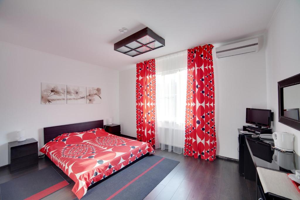 梁赞Hotel Odisseya的一间卧室配有红色的床和红色窗帘