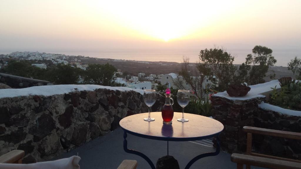 伊亚阿伦尼斯特拉伊亚公寓的两杯酒坐在桌子上,欣赏日落美景