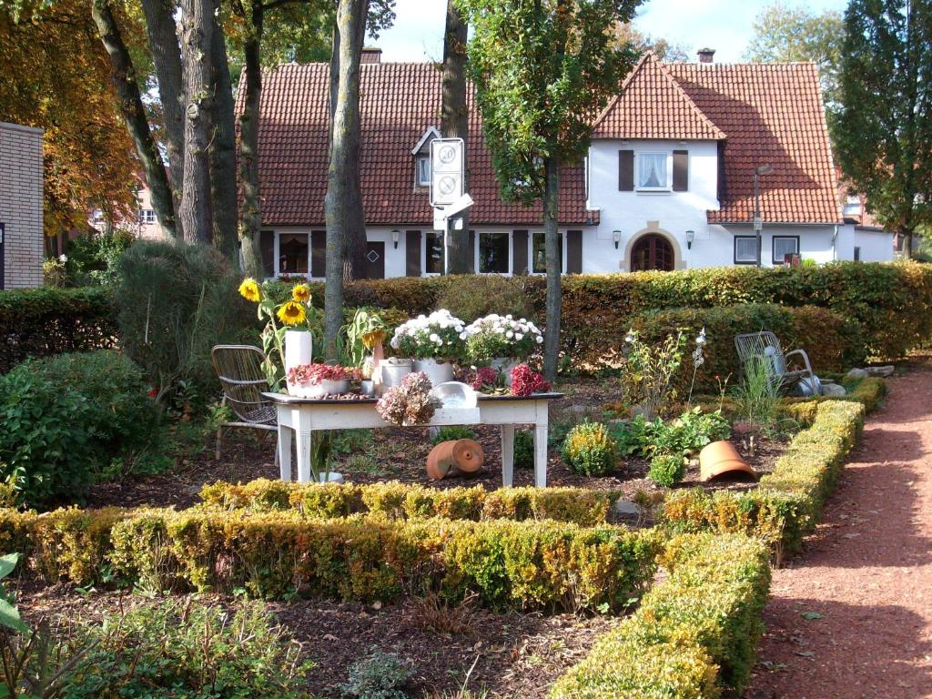 RekenGästezimmer Lammersmann的花园,位于一座鲜花盛开的桌子前