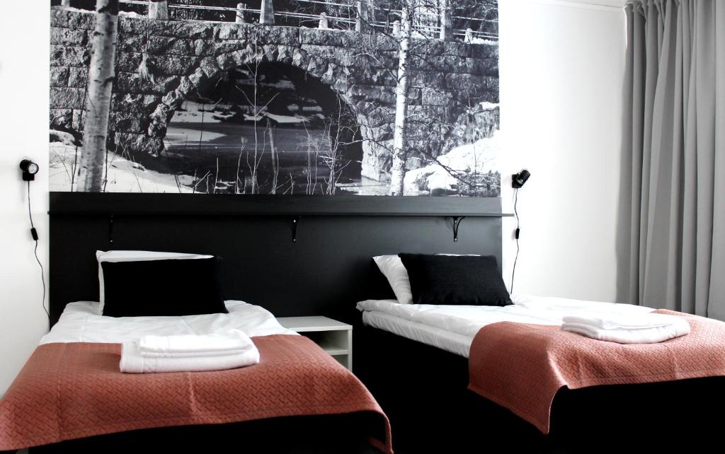 拉赫Forenom Aparthotel Raahe的两张睡床彼此相邻,位于一个房间里