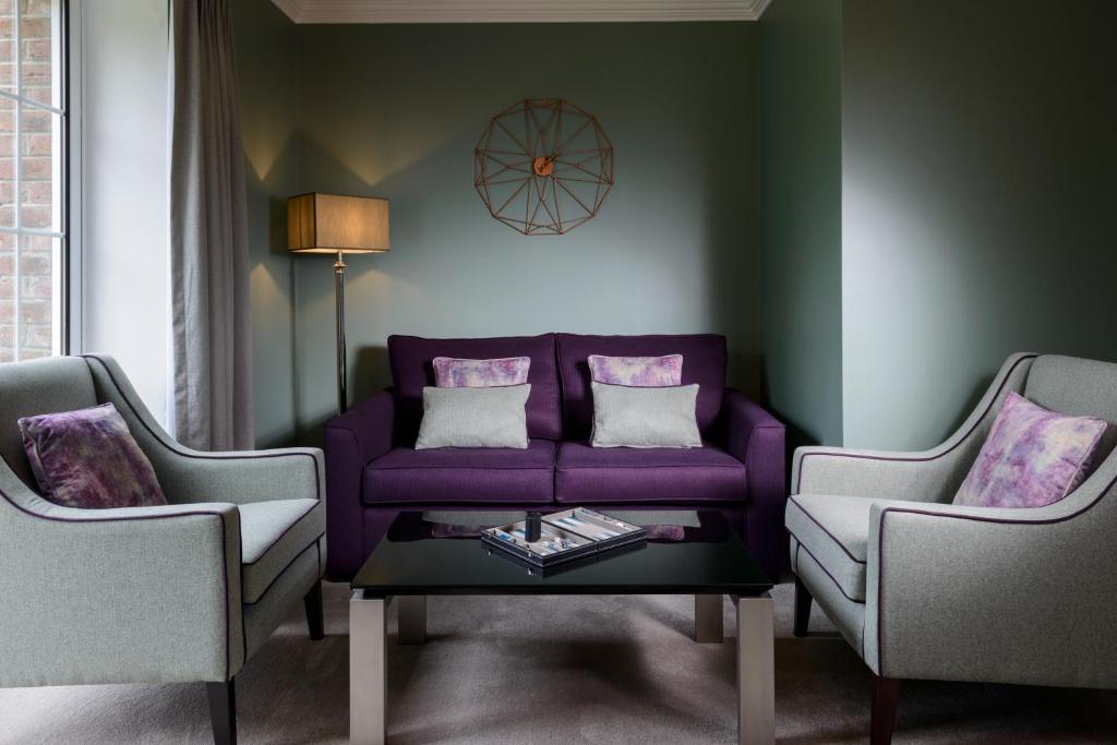 基拉尼The Reserve at Muckross Park的客厅配有紫色沙发和两把椅子
