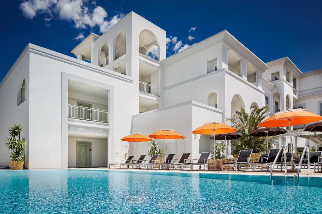 奥尔比亚爵士酒店的一座带游泳池和橙色遮阳伞的别墅