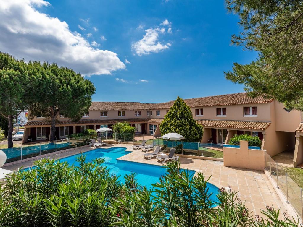 艾格-莫尔特Noemys Aigues-Mortes - Hotel avec piscine的一个带椅子和遮阳伞的度假游泳池