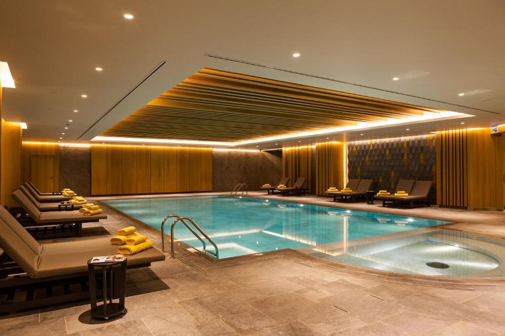 伊斯坦布尔维斯莫尔伊斯坦布尔酒店的游泳池位于酒店客房内,配有椅子和桌子