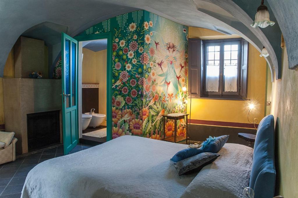 Candia Canavese伦纳福戈拉住宿加早餐旅馆的卧室配有一张大床,墙上挂有绘画作品