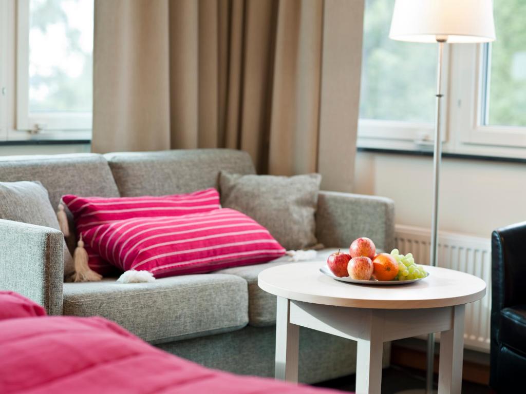 HörbyRingsjöstrand Hotel的客厅配有沙发和带一碗水果的桌子