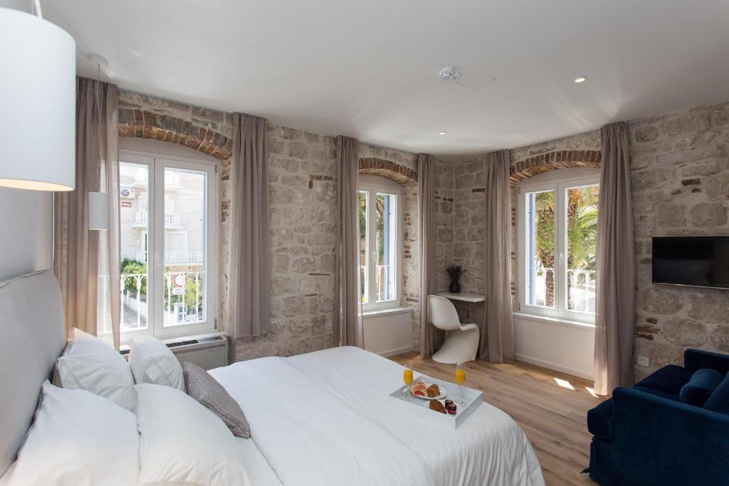 特罗吉尔Bifora Heritage Hotel的卧室设有白色大床和窗户。