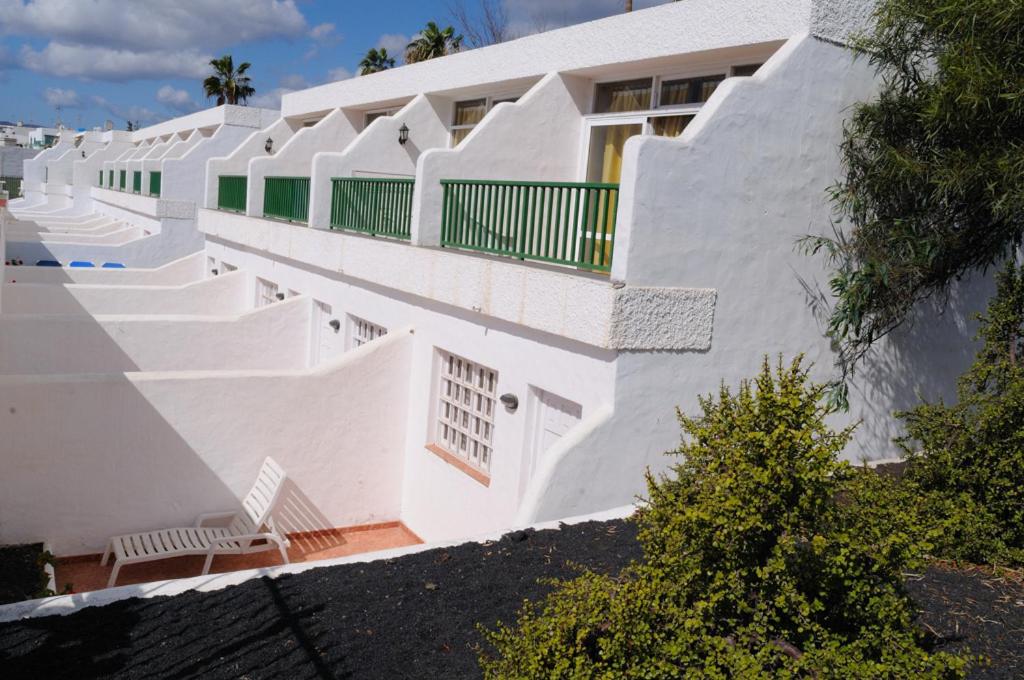 卡门港瓜纳拉玛公寓酒店的白色的建筑,拥有白色的墙壁和楼梯