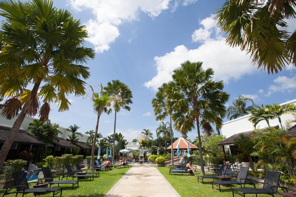 卡伦海滩Access Resort & Villas - SHA Plus的棕榈树和椅子的公园和人行道