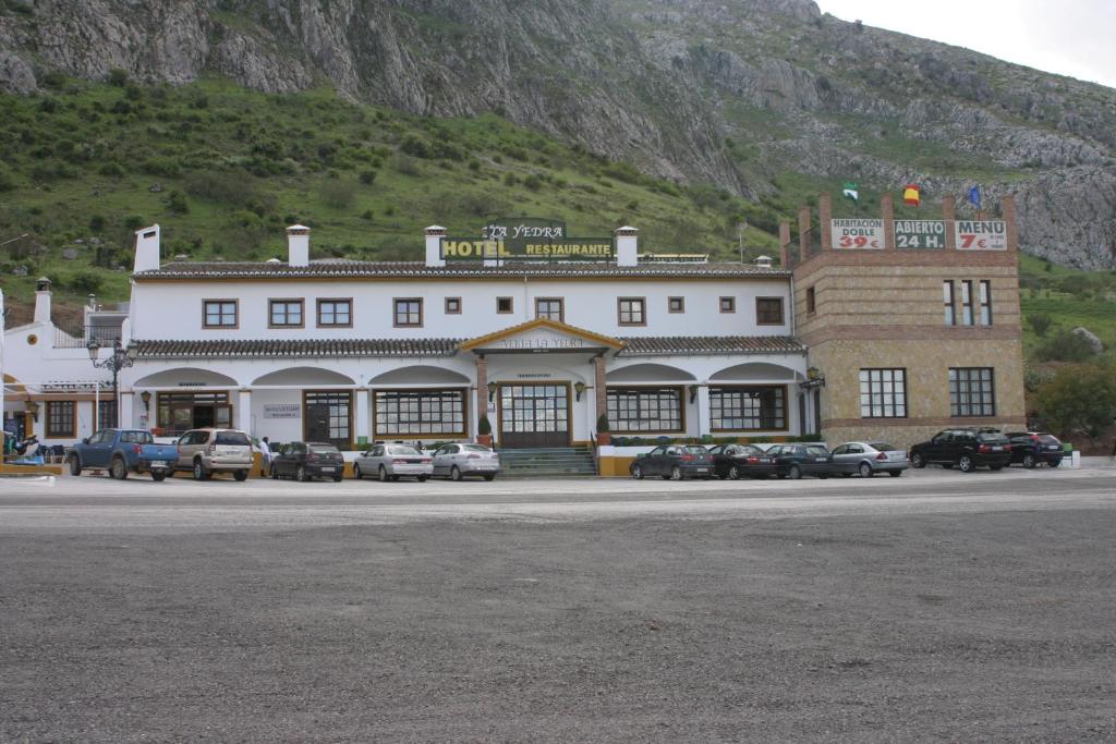 安特克拉拉耶德拉酒店的一座大型建筑,前面有汽车停放
